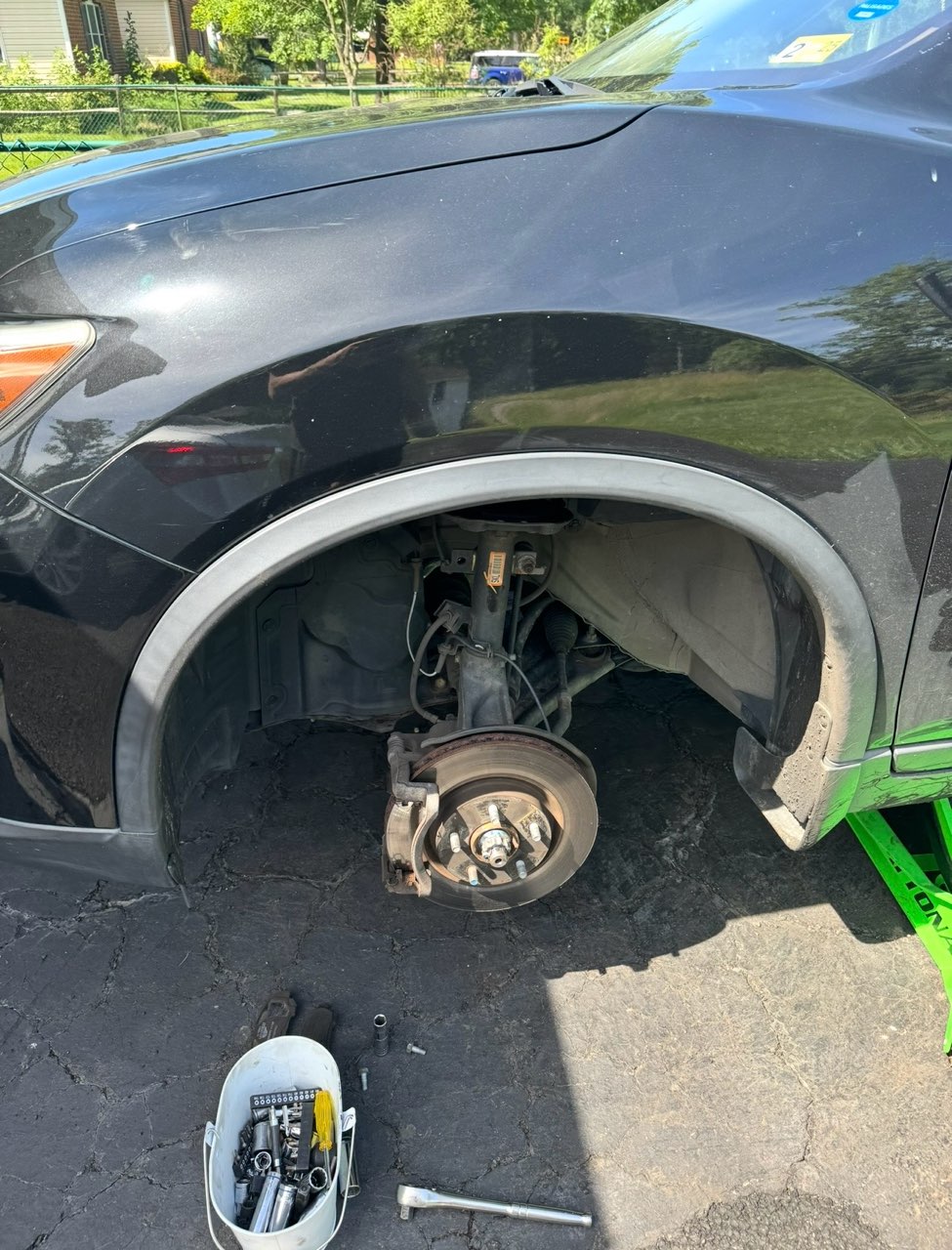 Wheel off and hardware staged for rotor and pad work.